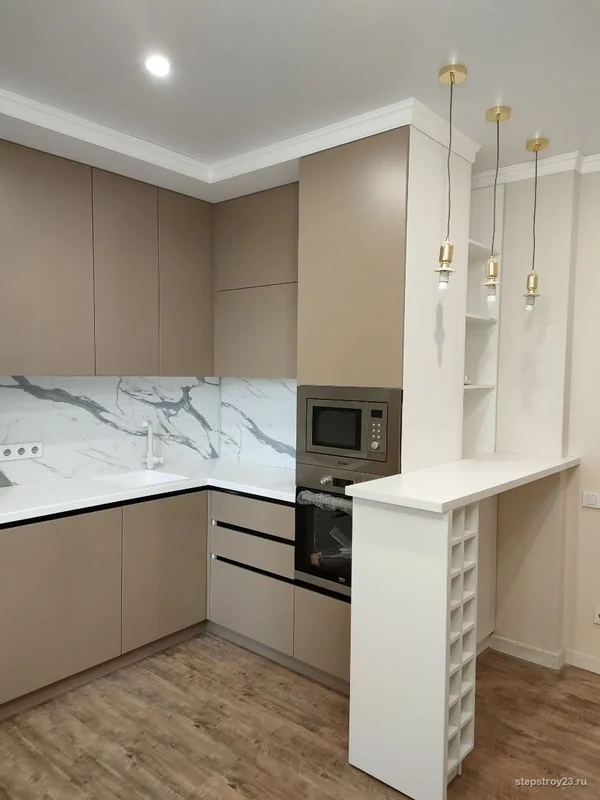 Бежевая кухня с мраморным фартуком и барной стойкой после ремонта